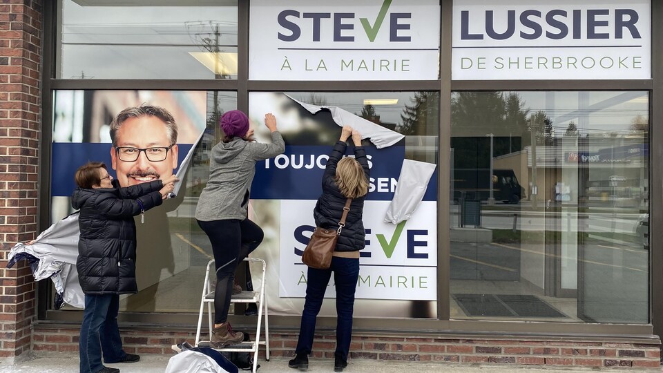 Des bénévoles retiraient, lundi matin, les affiches ornant les vitrines du local de campagne de Steve Lussier.