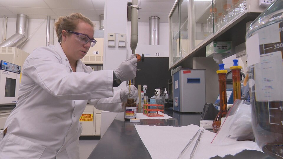 Une employée de BioVectra mélange des produits chimiques dans une fiole.
