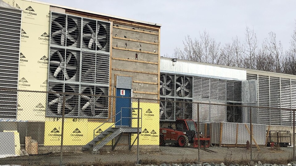 Une dizaine de gros ventilateurs ornent l'arrière de l'édifice de l'usine de cryptomonnaie Bitfarms. 