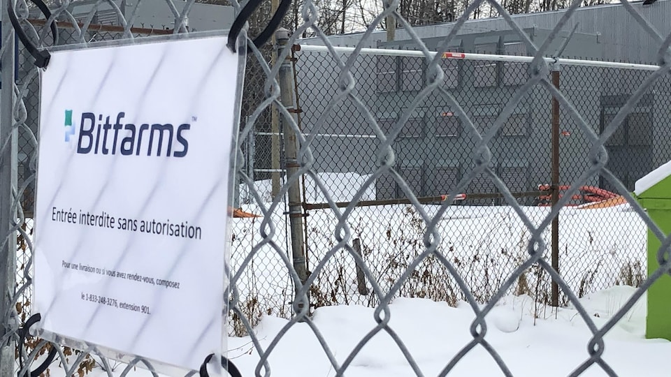 Les murs de l'usine Bitfarms. Une affiche indique qu'il est interdit d'y entrer sans autorisation.