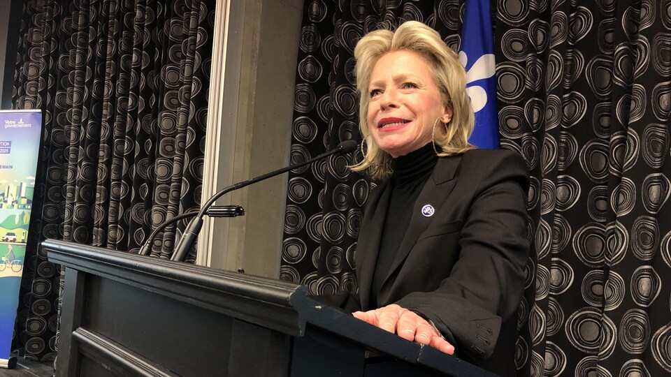 Caroline Proulx parle derrière un lutrin.