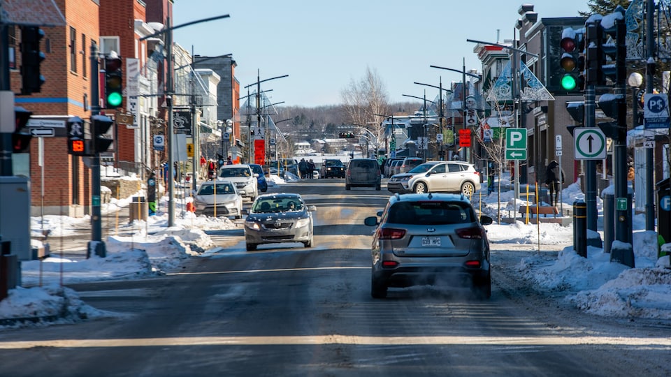 Des voitures circulent au centre-ville de Magog, en hiver.