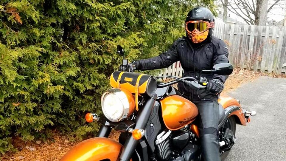 Une femme avec un casque sur une motocyclette.