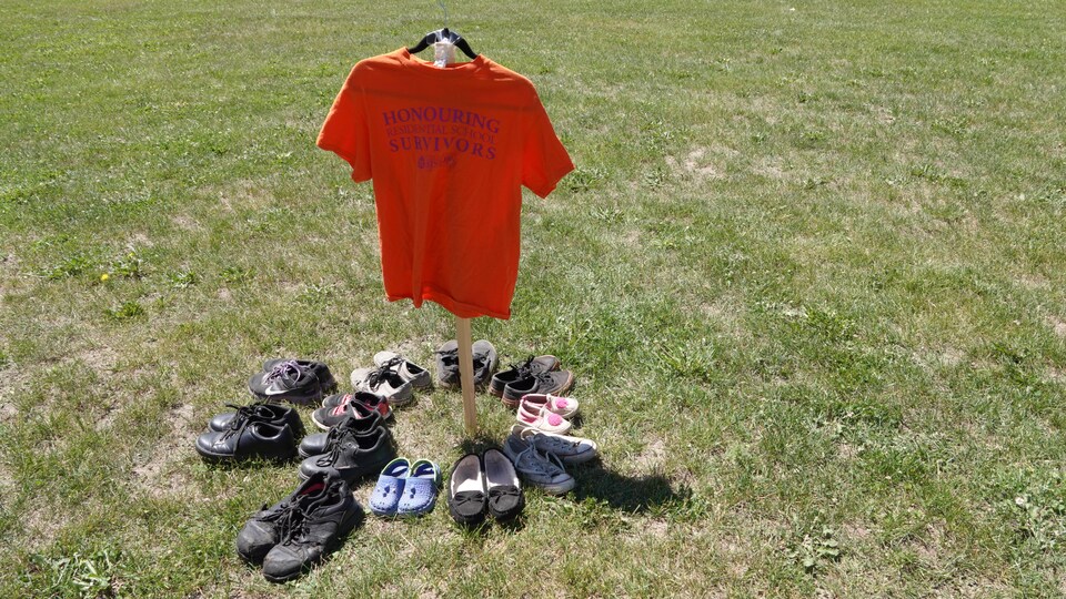 Un t-shirt orange entouré de chaussures.