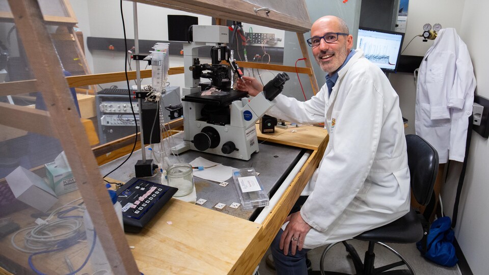 Portrait du professeur Altier dans son laboratoire devant un microscope à Calgary, en mai 2022.
