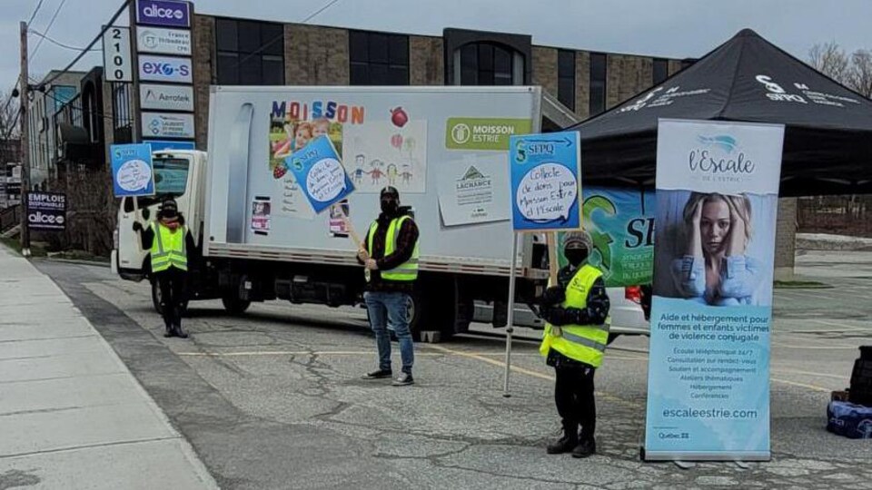 Trois employés de la fonction publique attendent l'arrivée des donateurs dans un stationnement à Sherbrooke.