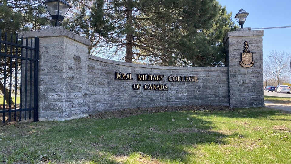 The insignia of the military college is engraved on a stone wall.