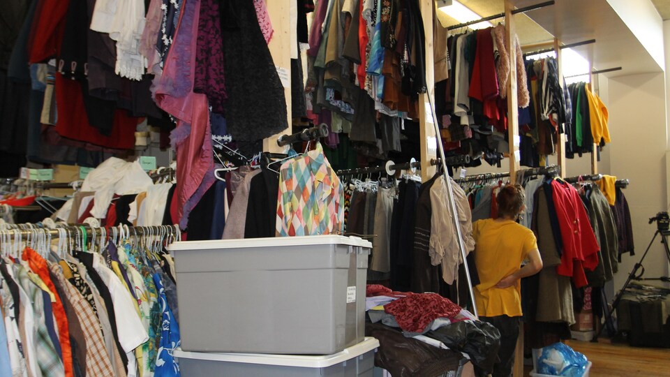 Des centaines de vêtements sont accrochés à des supports.