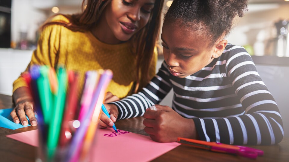 Une mère et son enfant colorient.
