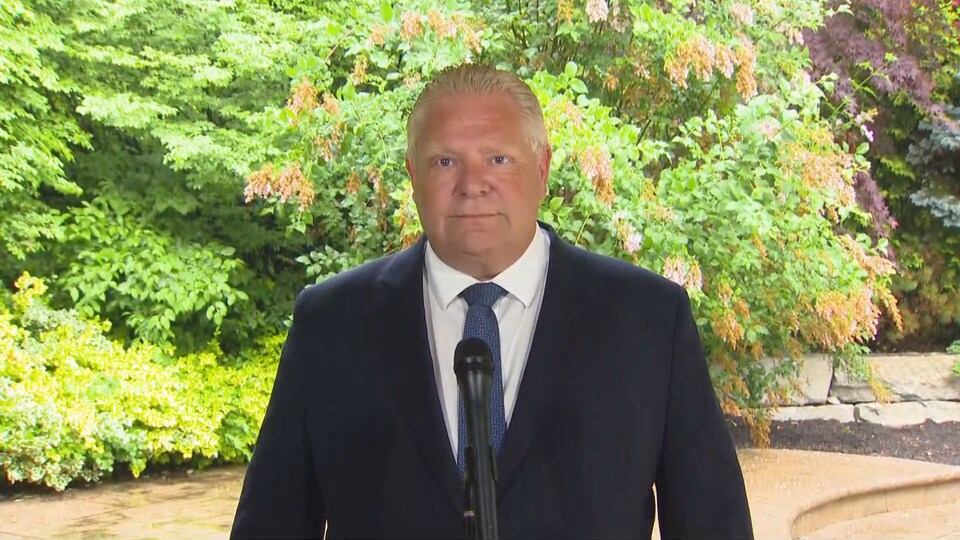 Doug Ford devant un micro.