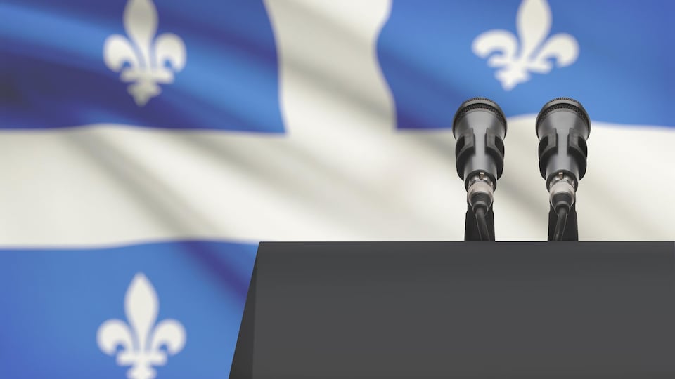 Deux microphones devant un drapeau du Québec.