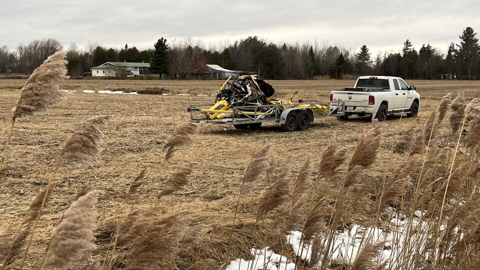 Un camion remorque la carcasse de l'hélicoptère de Sylvain Desmarais.