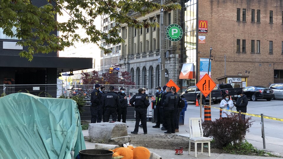 Des officiers de police présents lors du démantèlement d'un campement de personnes sans abri.