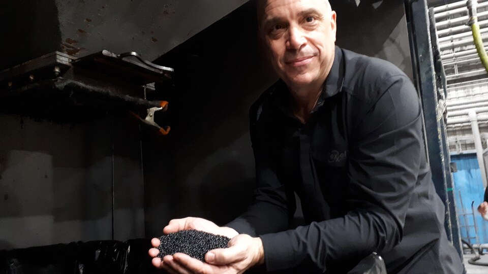 Éric Fradette montre une poignée de billes de plastique