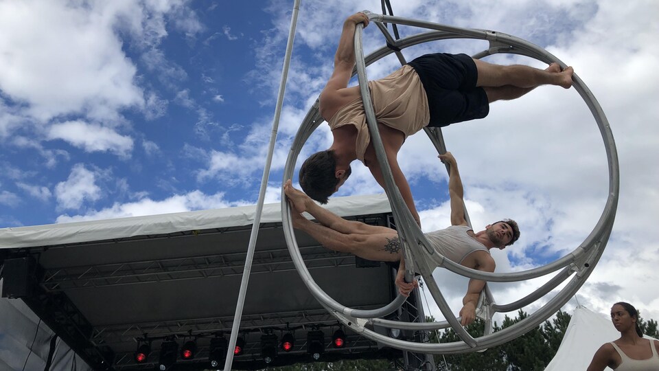 Deux acrobates à l'œuvre devant une scène.