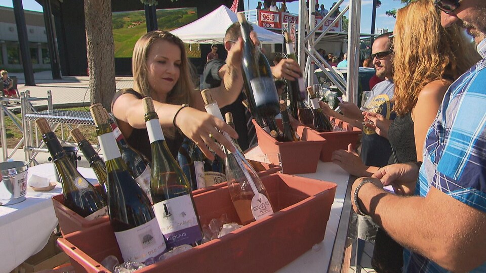 Une femme sert du vin aux visiteurs.