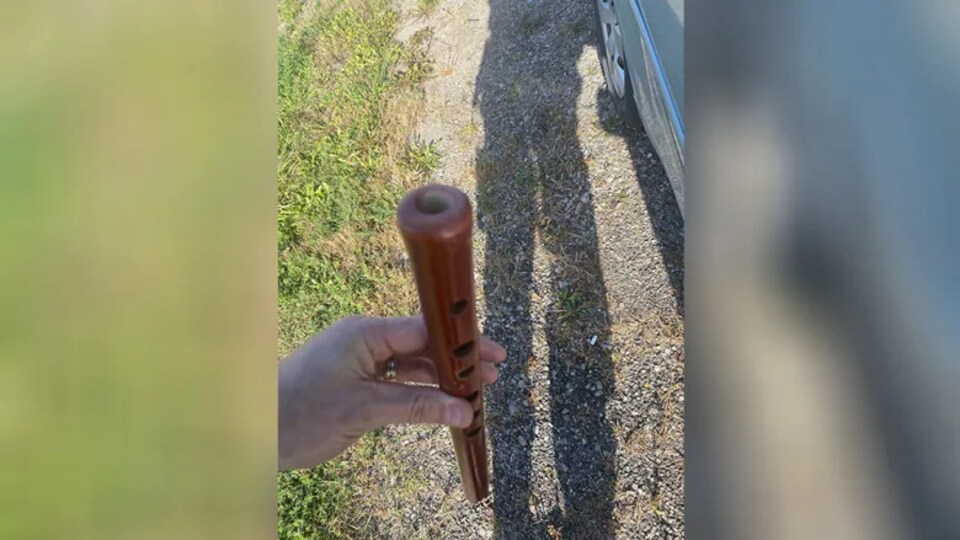 Un agent de police montre une flûte saisie lors de l'intervention.