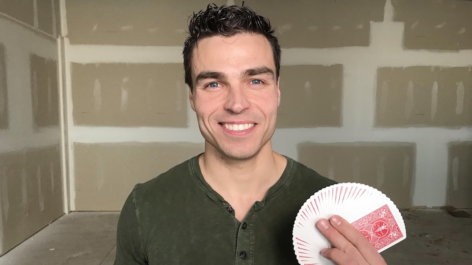 Roger Boucher dans une salle de répétition avec des cartes dans sa main