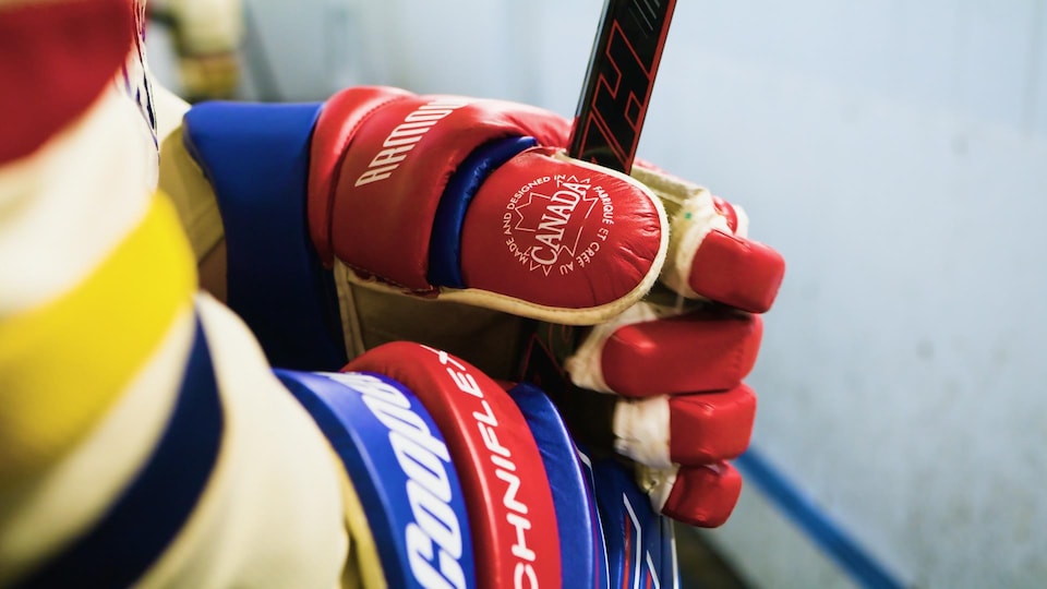 Le gant et le baton de hockey d'un membre de l'équipe de hockey les Voyageurs sur le banc