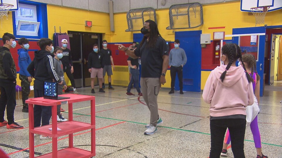 Georges Laraque s'adresse aux élèves dans le gymnase de l'école Marie-Reine.