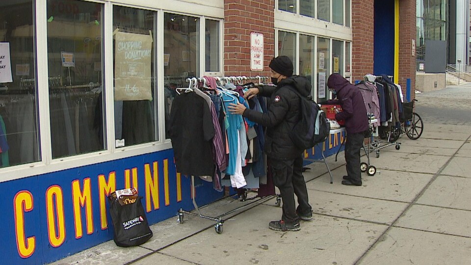 Des personnes regardent un présentoir à vêtements devant une boutique de Calgary.