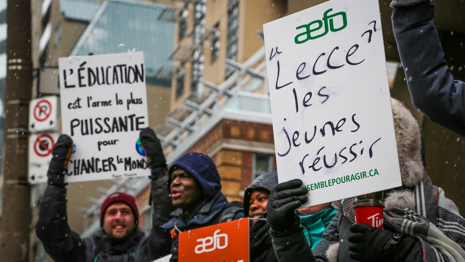 Des enseignants manifestent. Une pancarte au premier plan indique « Lecce les jeunes réussir ».