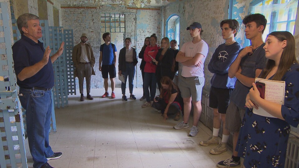 Un guide explique à des étudiants l'histoire de la prison Winter à l'intérieur de celle-ci.