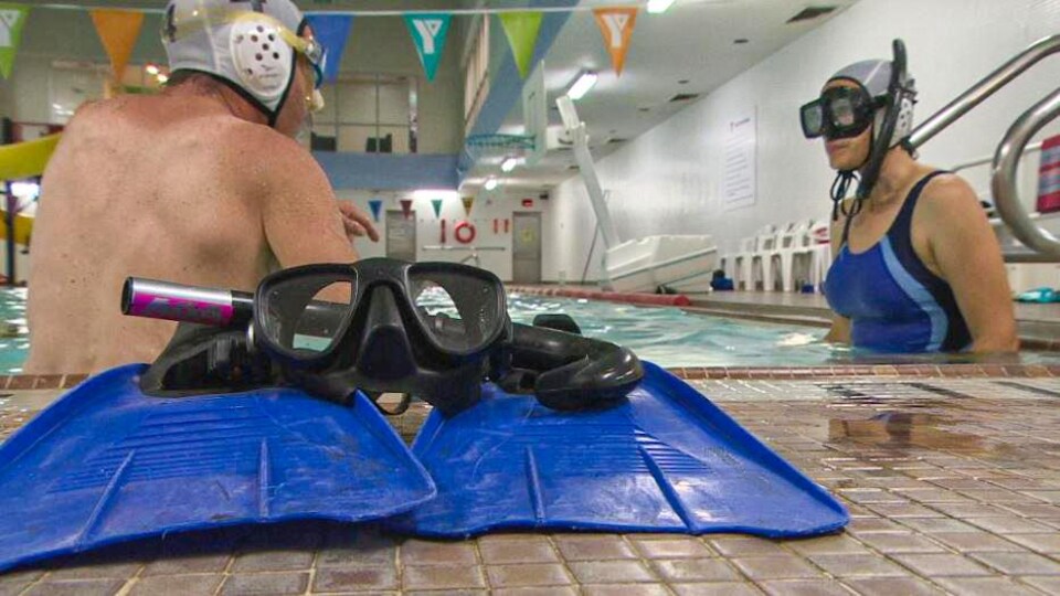 Des palmes et un masque sont au bord de la piscine.  