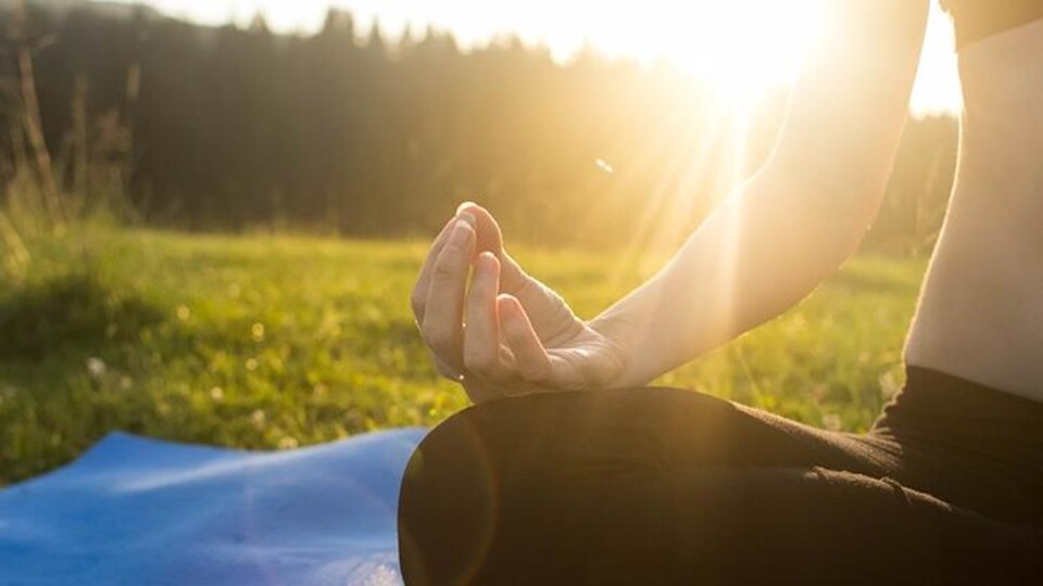 Une femme fait du yoga à l'extérieur 