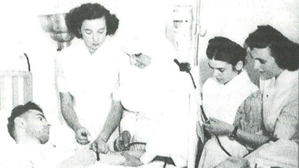 Photo de trois infirmières, d'une religieuse et d'un patient lors d'une formation à l'Hôtel-Dieu d'Edmundston