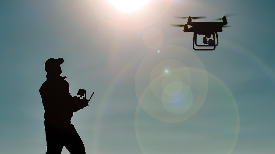 Un homme qui pilote un drone.