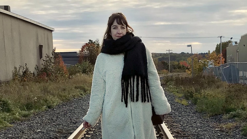 Iris Boudreau, debout au milieu d'un chemin de fer.