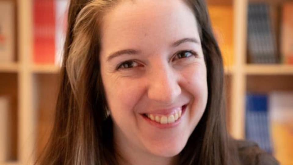 L'autrice et illustratrice Iris Boudreau sourit devant une bibliothèque.