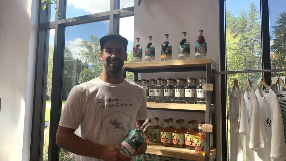 Un homme qui tient une bouteille de gin.