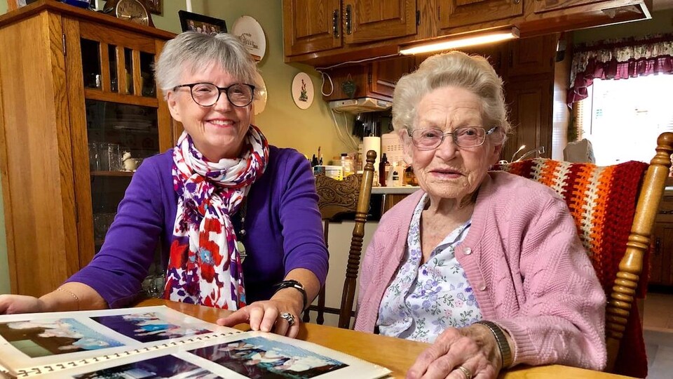 Deux femmes âgées regardent un album photo.