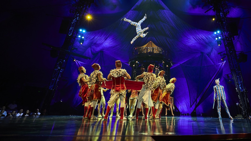 Une troupe de cirque en performance sur une scène.