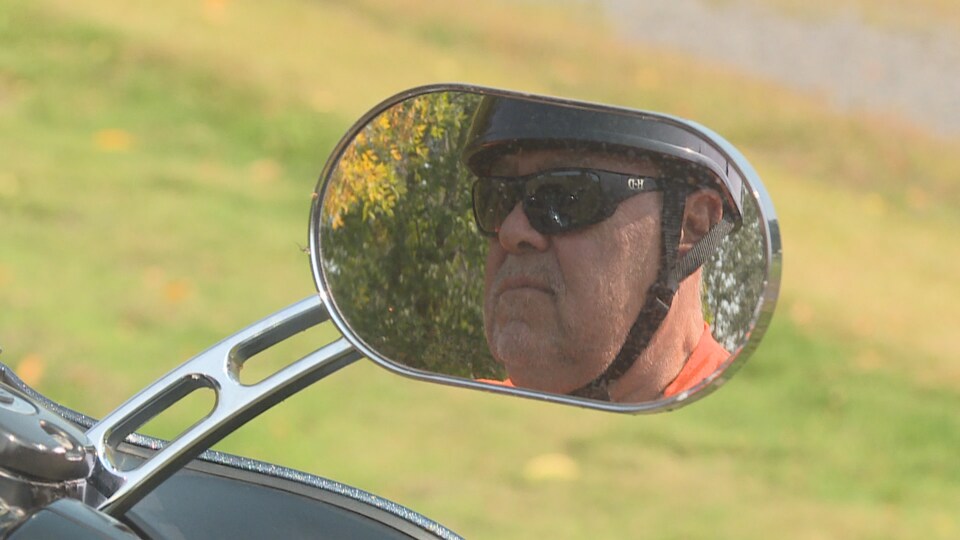 Portrait de l'homme dans un rétroviseur de moto.