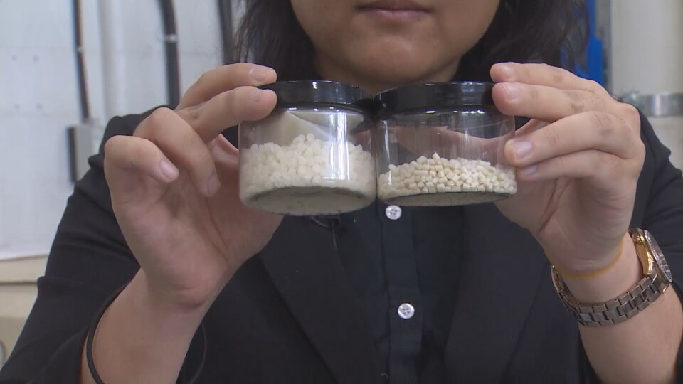 Une femme montre des échantillons de son produit de plastique biodégradable.