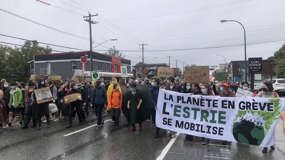Des centaines d'étudiants marchent, pancartes à la main, sur la rue King à Sherbrooke.