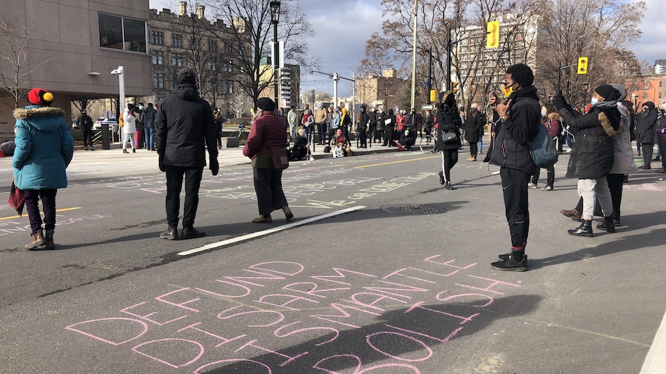 Des manifestants devant le quartier général du Service de police d'Ottawa sur la rue Elgin.