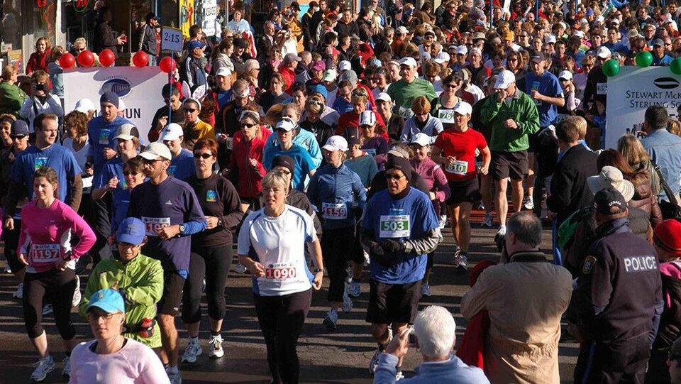 Plusieurs personnes qui courent un marathon dans les rues de Charlottetown.