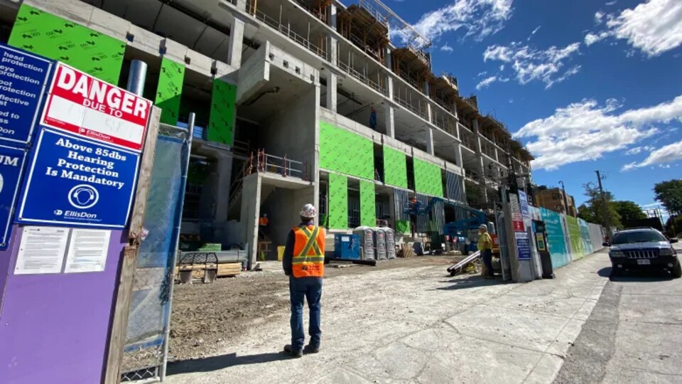 Un ouvrier du bâtiment regarde le chantier.
