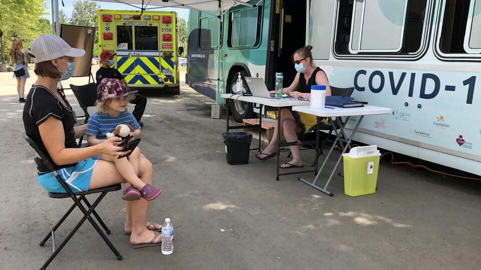 Une femme attend d'être vaccinée devant un autobus