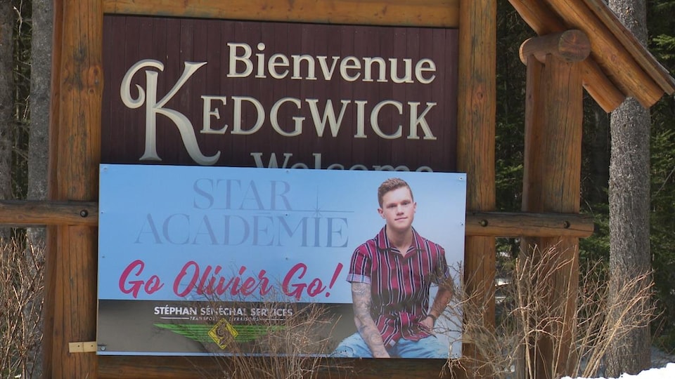 Une affiche d'Olivier Bergeron installée sur l'enseigne du village de Kedgwick.