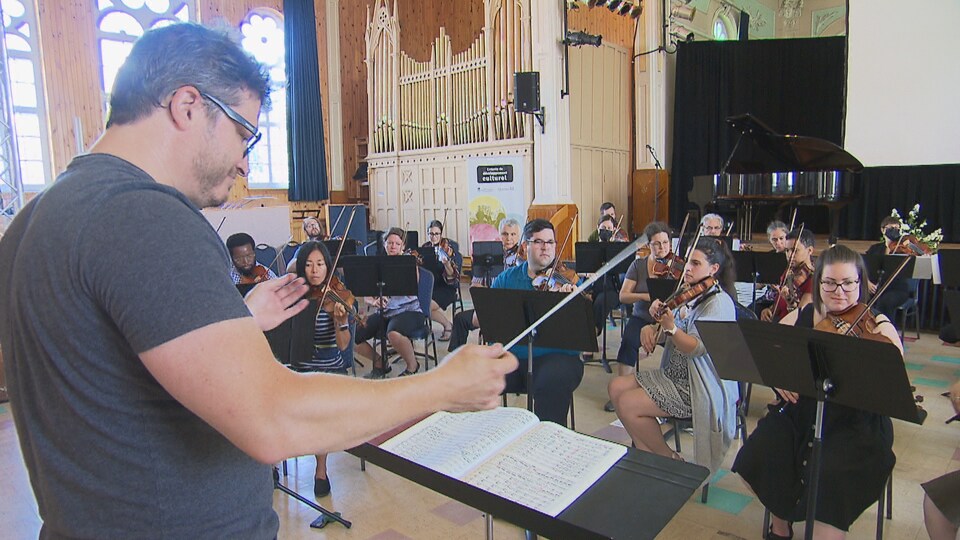 Un chef d'orchestre dirige des musiciens.