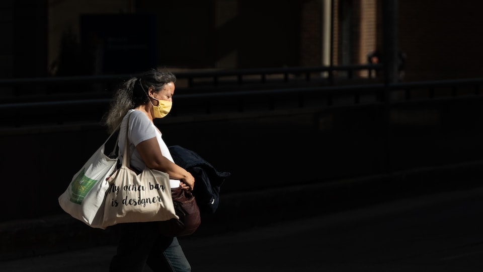 Une femme marche sur la rue Queen à Ottawa.