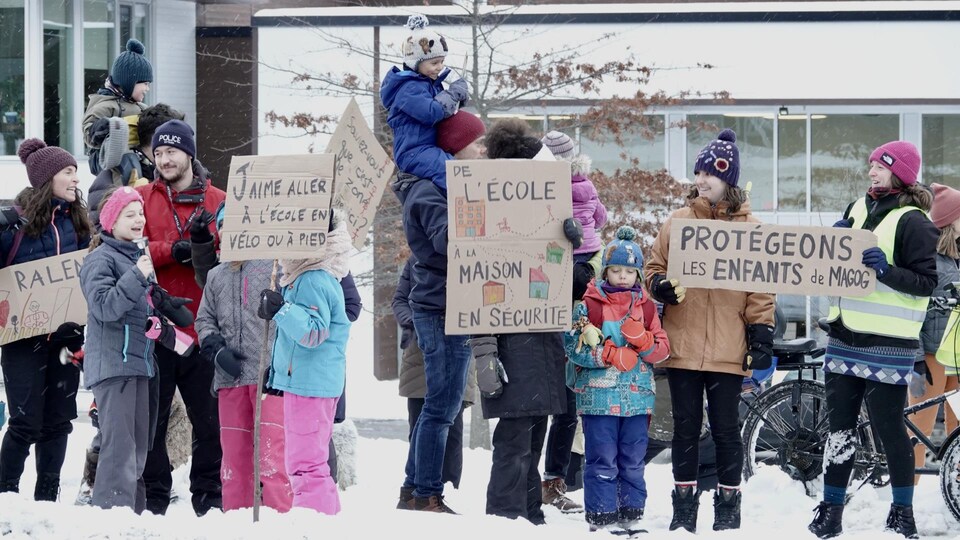 Des parents et des élèves manifestent devant l'École Montessori à Magog.                             