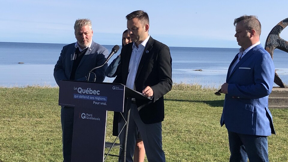 Paul St-Pierre Plamondon entouré de députés avec en arrière plan le fleuve Saint-Laurent.