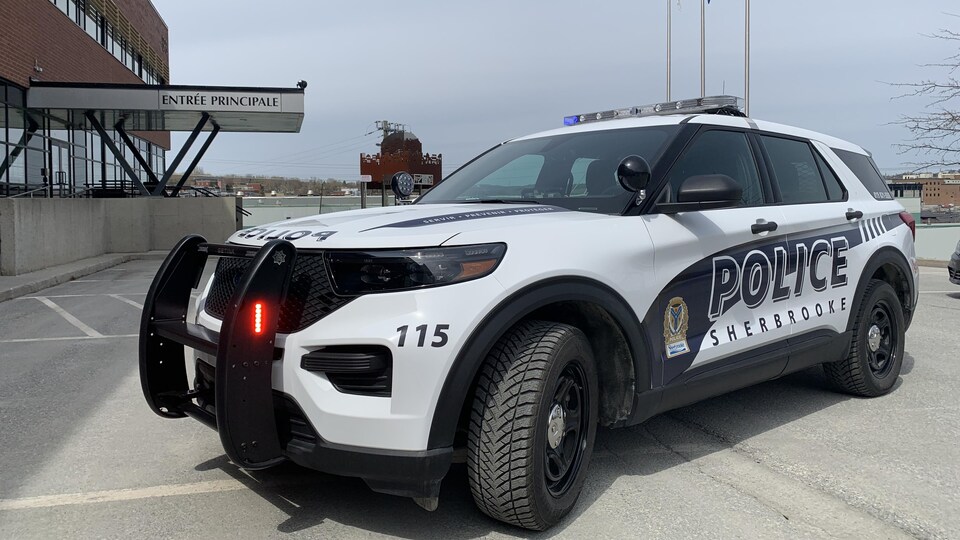 Un VUS de la police de Sherbrooke est stationné devant l'entrée principale du poste, gyrophares en marche.