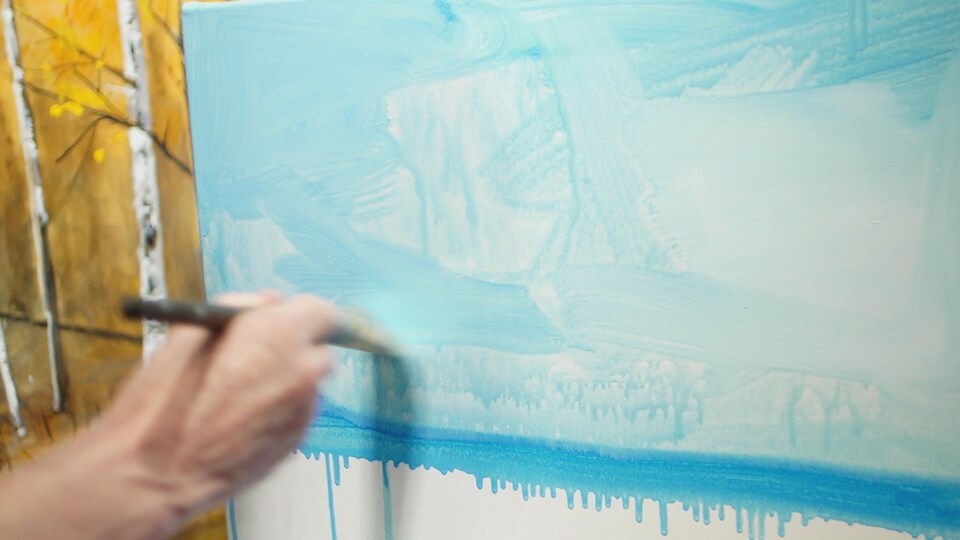 L'artiste prépare son lavis à l'aide d'une brosse  et d'une peinture diluée. 